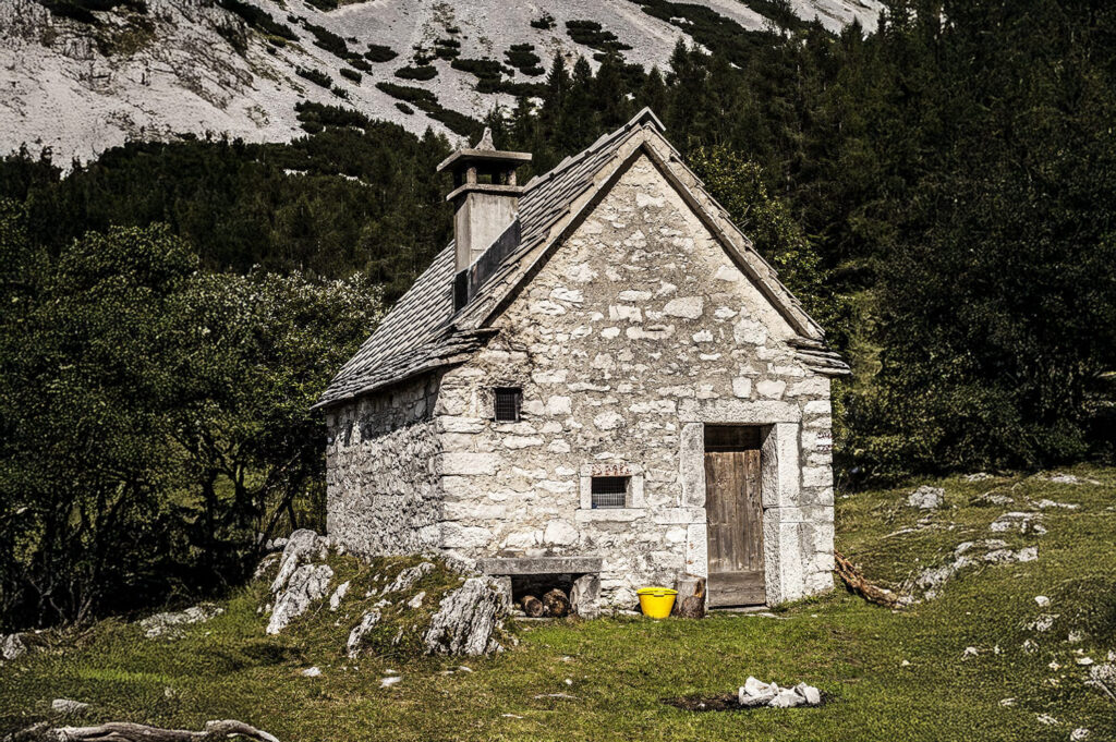 Antica casera in pietra ai piedi delle montagne dell'Alpago